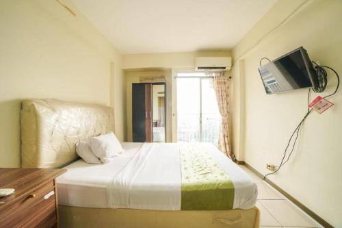 a bedroom with a bed with a tv on the wall at Bogor Valley Hotel in Bogor