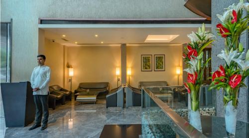 a man standing in a hotel lobby with flowers at The Mirador in Mumbai