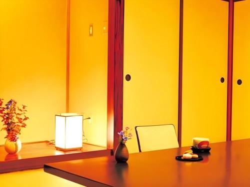 a room with a table with a vase with flowers on it at Shirako New Seaside Hotel in Shirako
