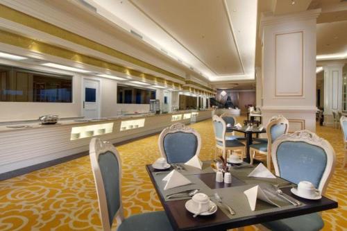 a restaurant with tables and chairs in a room at Adimulia Hotel Medan in Medan