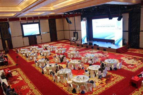 a large banquet hall with tables and chairs and a screen at Adimulia Hotel Medan in Medan