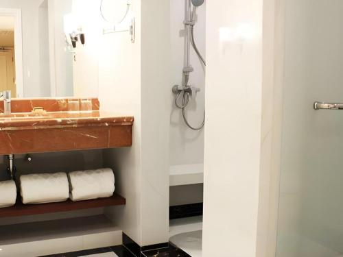 a bathroom with a sink and a mirror at Adimulia Hotel Medan in Medan