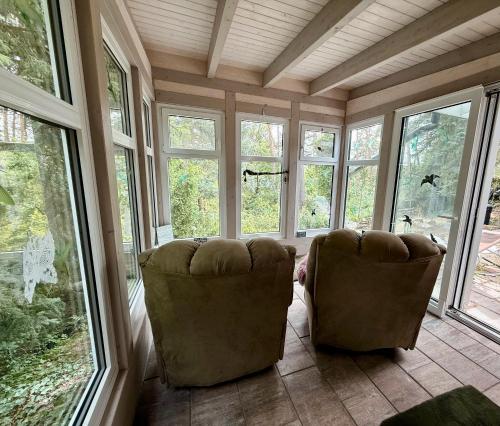 two chairs sitting in a room with windows at Lakeside-Hideaway in Schenkendöbern
