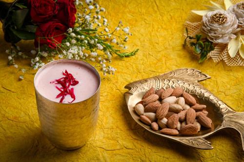 a bowl of almonds next to a cup of milk at The Mirador in Mumbai