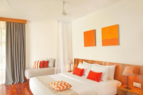 a bedroom with two beds with red and orange pillows at Templation Hotel in Siem Reap