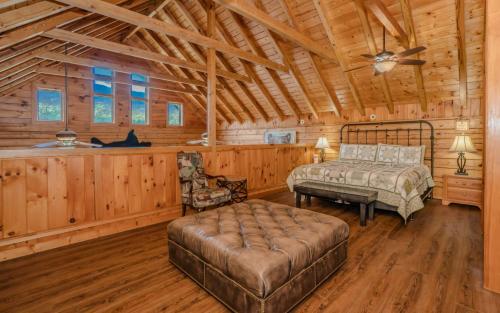 a bedroom in a log cabin with a bed and a couch at Pop A Bear in Pittman Center