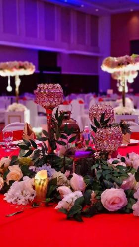 a table with pinkcandles and flowers on a red table at RH Hotel Sibu in Sibu