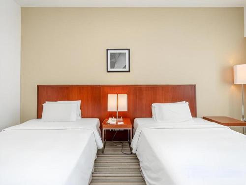 two beds sitting next to each other in a room at RH Hotel Sibu in Sibu