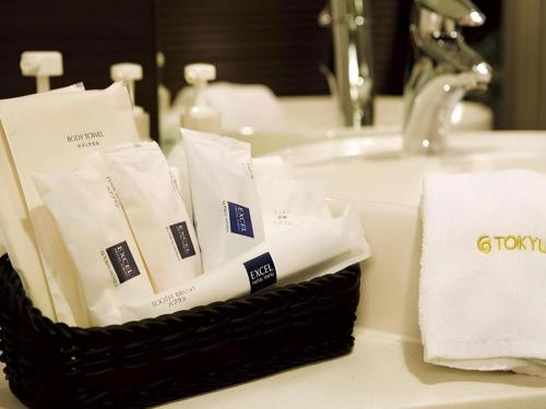a basket of toiletries sitting on a bathroom sink at Akasaka Excel Hotel Tokyu in Tokyo
