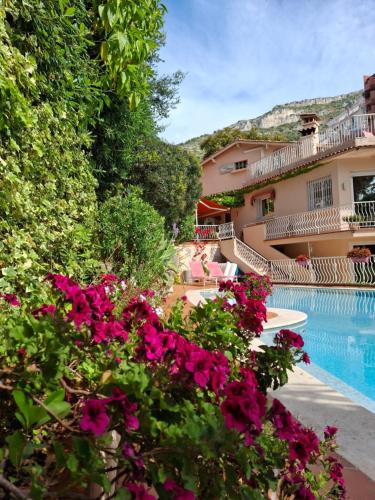 un complexe avec une piscine et des fleurs dans l'établissement Villa Silhouette with pool and seaview close to Monaco, à Cap d'Ail