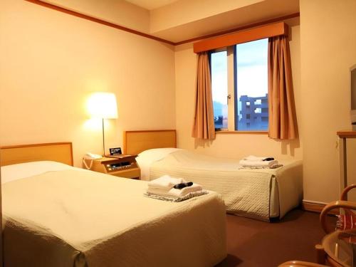 a hotel room with two beds and a window at Okinawa Sunplaza Hotel in Naha