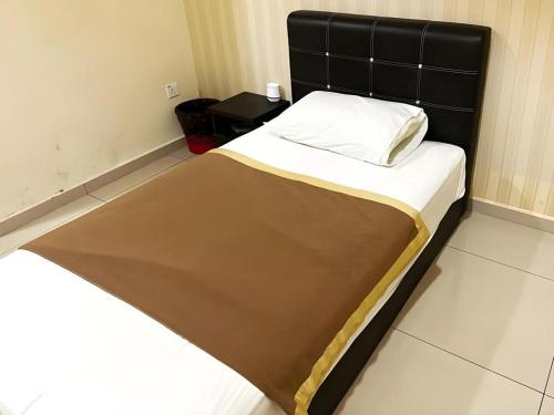 a bed with a black headboard in a room at RST Hotel in Johor Bahru
