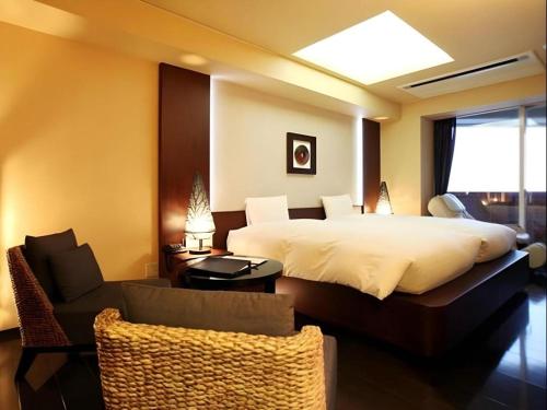 a bedroom with a large bed and a living room at Luxury Wa Hotel Kaze No Kaori in Ito