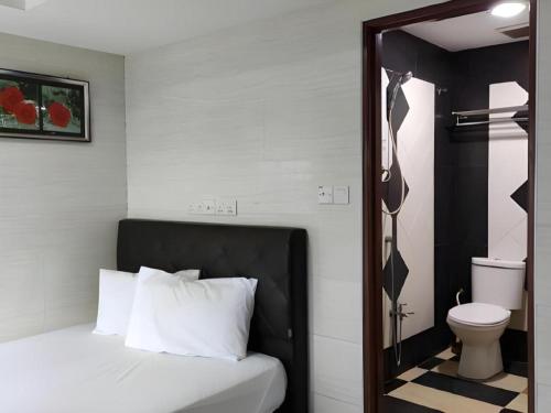 a bedroom with a bed and a toilet and a mirror at Kota Damansara Business Hotel in Kepong Cubitt Forest Village