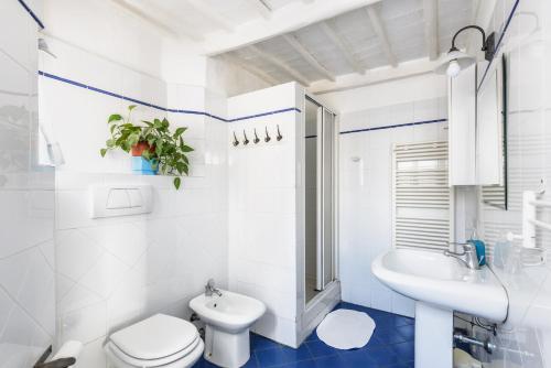 a white bathroom with a toilet and a sink at Casa di Osio in Siena