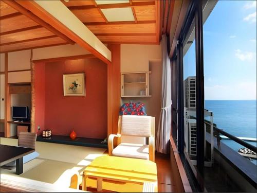 a living room with a view of the ocean at Tsukino Sumika Atami Juraku Hotel in Atami