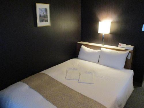a large white bed in a hotel room at Niigata Keihin Hotel in Niigata