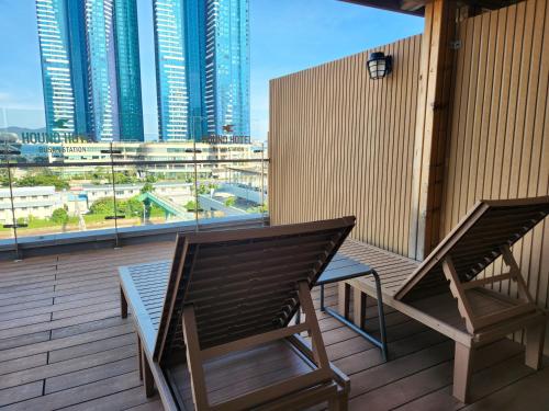 two chairs on a balcony with a view of a city at Hound Hotel Busan Station in Busan