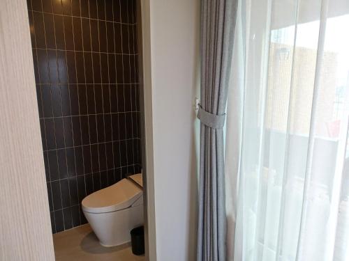 a bathroom with a toilet and a shower at Hound Hotel Busan Station in Busan