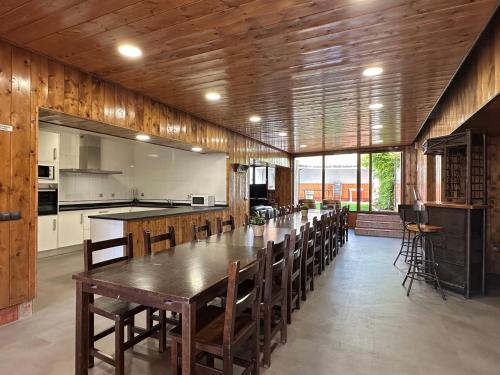 a large kitchen with a long wooden table and chairs at Casa Leuza in Espronceda