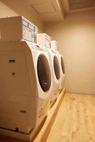a row of white washing machines in a laundry room at HOTEL CLAD in Fuji