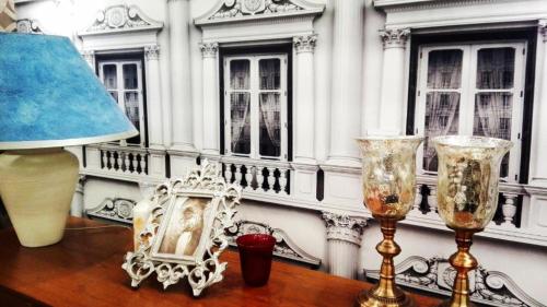 a table with a lamp and two glasses on it at Central Apartments in Poznań