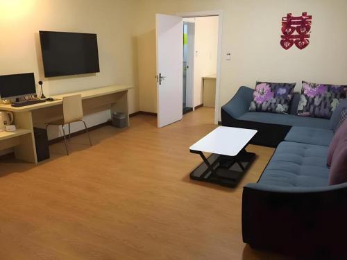 - un salon avec un canapé bleu et un bureau dans l'établissement 7 Days Inn Jiamusi Tangyuan County Shengli Road, à Jiamusi