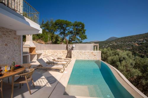 une villa avec une piscine et une table et des chaises dans l'établissement Villa Oliva -Seaside Charm with Village at Your Doorstep, à Sývota
