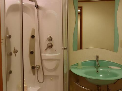 a bathroom with a green sink and a shower at Chino Station Hotel in Chino