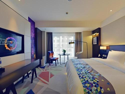 a hotel room with a large bed and a desk at Zmax Hotel·Xining Wanda Plaza in Xining