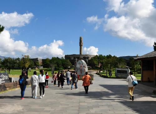 a group of people walking in front of a statue at James Joyce Coffetel·Lijiang Old Town Centeral in Lijiang