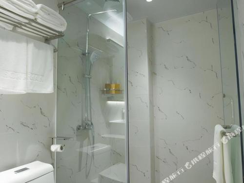 a bathroom with a glass shower and a toilet at Borrman Hotel Zhuhai Gongbei Port Fuhuali Light Rail in Zhuhai