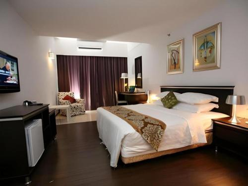 a hotel room with a large bed and a living room at Ritz Garden Hotel in Ipoh