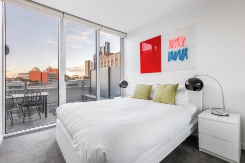 a bedroom with a white bed and a large window at 'Swanston Central' Wellness-infused City Living in Melbourne
