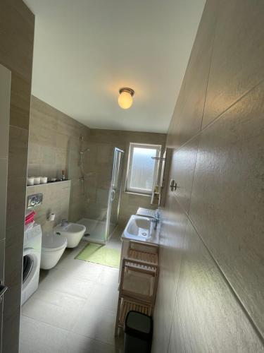 a bathroom with two toilets and a sink and a mirror at Apartman Damir in Malinska