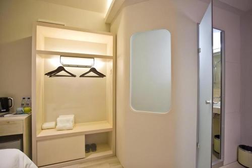 a room with a closet with a mirror and a door at M Plus Boutique Hotel in Gelang Patah