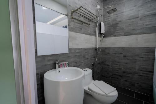 a bathroom with a sink and a toilet at Kimal Hotel Taiping in Taiping
