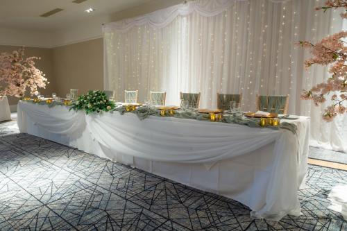 a long white table with glasses and flowers on it at Holiday Inn Newcastle Gosforth Park by IHG in Newcastle upon Tyne