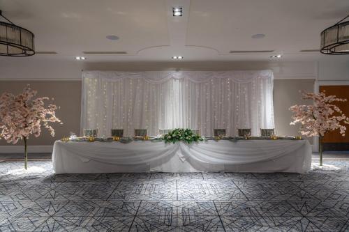 a table in a room with a white curtain and flowers at Holiday Inn Newcastle Gosforth Park by IHG in Newcastle upon Tyne