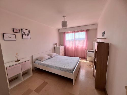 une petite chambre avec un lit et une fenêtre dans l'établissement Appartement Le Cannet, au Cannet