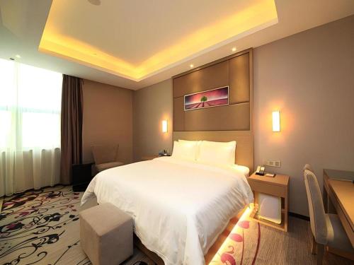 a hotel room with a large bed and a desk at Shenzhen Lavande Hotel Airport Terminal Branch in Shenzhen
