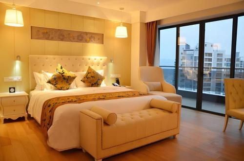 a large bedroom with a large bed and a chair at Wyndham Garden Hotel in Lingshui