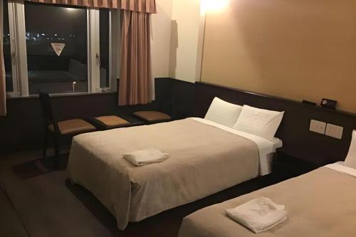 a hotel room with two beds and a window at Hotel Gran View Okinawa in Naha