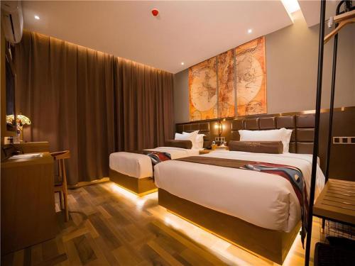 a hotel room with two beds and a map on the wall at James Joyce Coffetel·Kaifeng Drum Tower in Kaifeng