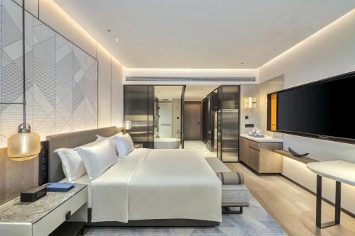 a hotel room with a bed and a television at Crowne Plaza Rugao in Nantong