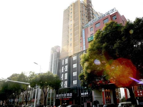 a tall building on a city street with cars at City Comfort Premier Hotel Xiaogan Anlu Railway Station Dongda Times Square in Xiaogan