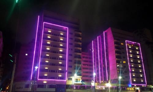 two tall buildings lit up in purple lights at Jewel San Stefano Hotel in Alexandria