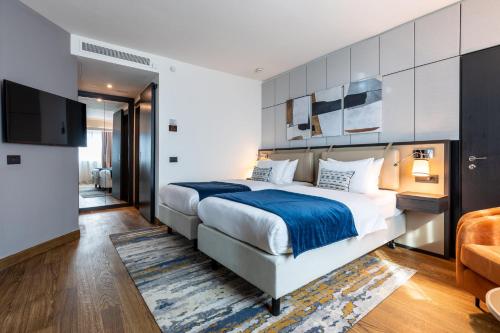 a bedroom with a large bed and a tv at Crowne Plaza Belgrade by IHG in Belgrade