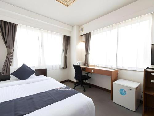 a hotel room with a bed and a desk at Hamakan Hotel in Unzen