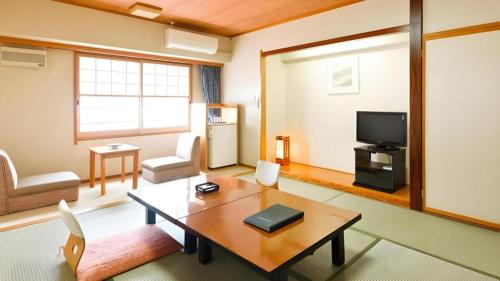 a living room with a table and a tv at Yuzawa New Otani in Yuzawa